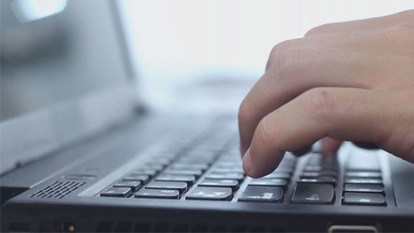 Man Typing on a Laptop