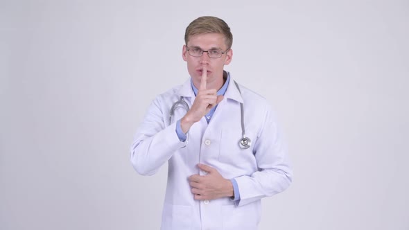 Serious Young Handsome Man Doctor with Finger on Lips