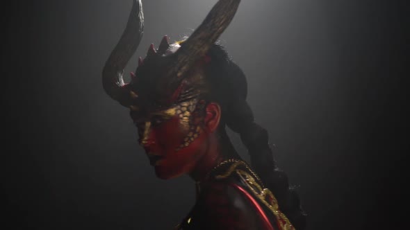 Slow motion footage of a woman with body art and makeup of a demon