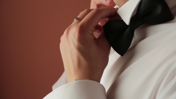 A Man In a White Shirt Dresses Black Tie