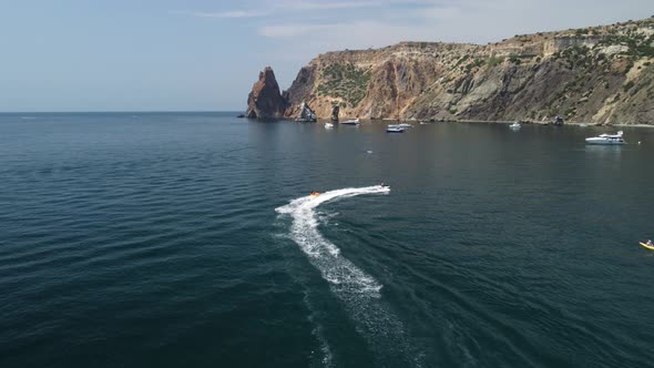 Happy People are Going to Swim on an Air Mattress Behind a Jet Ski