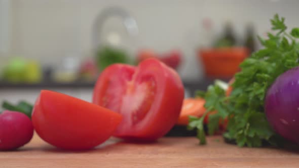 Colorful Fresh Vegetables On Cutting Board In Kitchen. Dolly Shot. Pieces Of Tomato