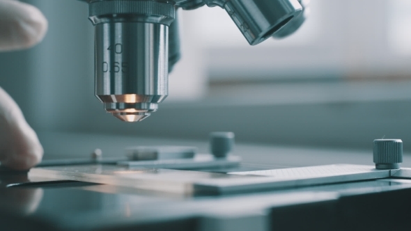 Scientist Using a Microscope In Laboratory