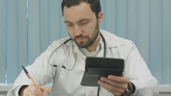 Young  Male Doctor With a Calculator Make Calculations And Make Notes