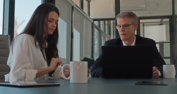 Two business partners having a meeting in an office to discuss a new project. Slow motion.