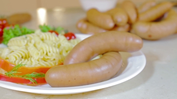 Sausages Served On Plate With Pasta And Vegetables