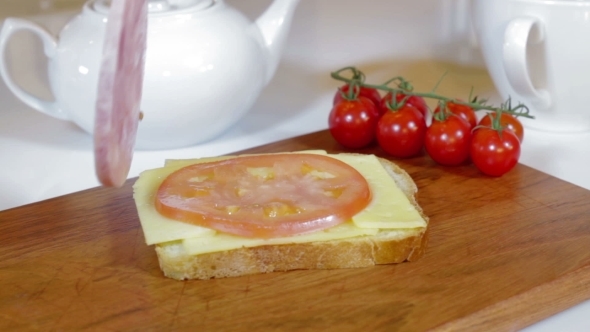 Making Sandwich With Tomato, Ham And Cheese