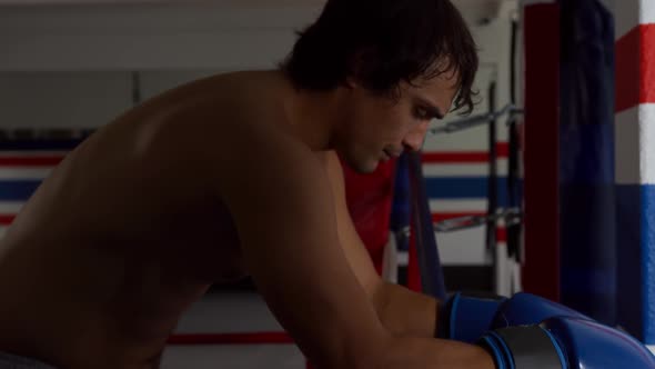 Caucasian man resting in boxing ring