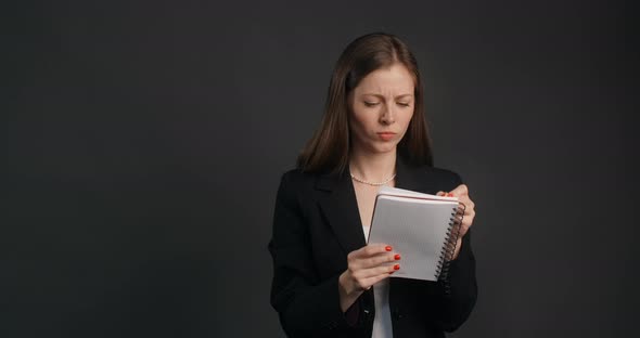 Vexed and Angry Woman in Black Suit Crosses Out Hes Notes in the Notepad  Prores HQ 120 Fps