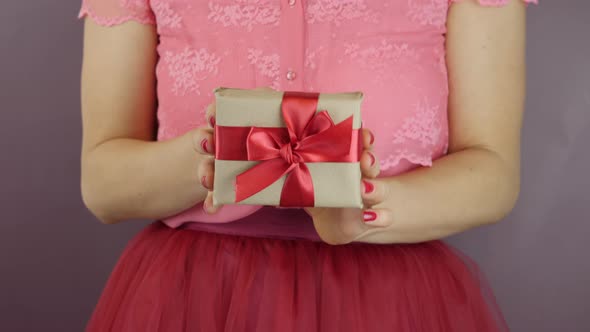 Wrapped in craft paper gift with tied bow for St. Valentine's Day, Birthday or Woman Day