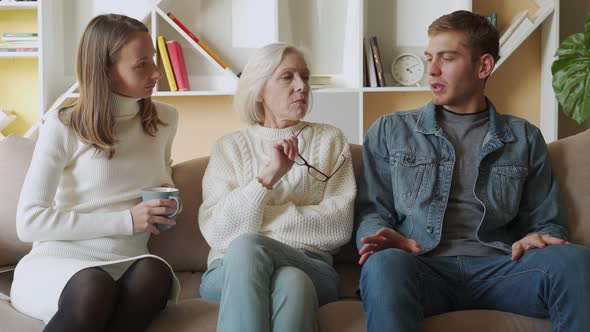 Elderly Mother and His Daughter Have a Warm and Friendly Conversation with Their Son at Home