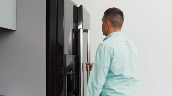 Man Taking Banana From Fridge at Home Kitchen