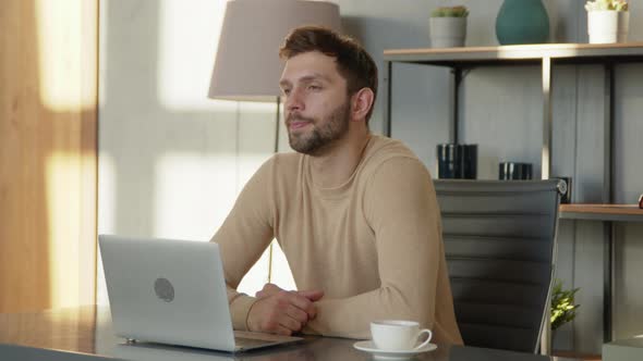 Young thinking male with laptop at remote work