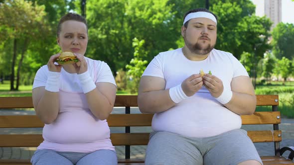 Fat Young Couple Eating Hamburgers, Addicted to Junk Food, Lack of Willpower