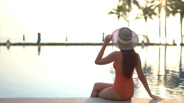 Young asian woman enjoy around outdoor swimming pool for leisure