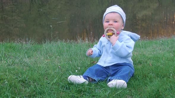 Cute Baby Sitting In The Grass