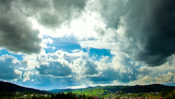 Clouds Over The Forest, Houses And Mountain alt