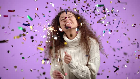 Curly Woman with Sparkling Bengal Fire Dancing Under Confetti Rain on Violet Background