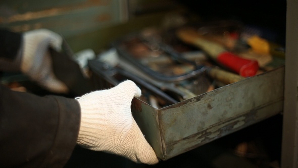 The Man Opens the Metal Closet and Pushes a Box of Tools