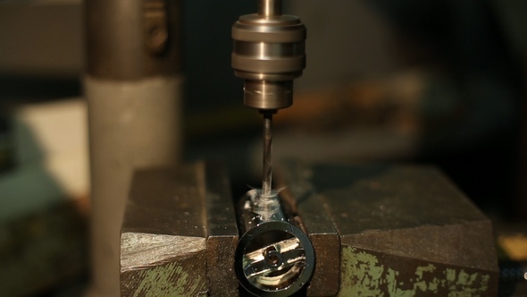 Man Drills a Detail on a Drilling Machine