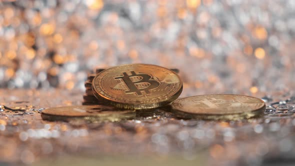 Bitcoin Coins Lie Against the Background of Gold Dust