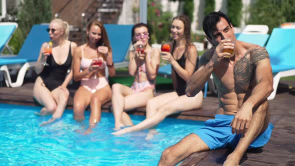 Confident Middle Eastern Tattooed Man Drinking Whiskey in Slow Motion Resting at Poolside in