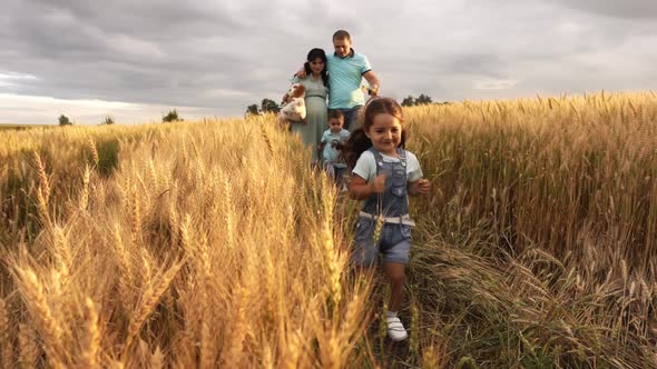 A Couple with Two Kids is Going in a Meadow at Summer Day in Slowmo