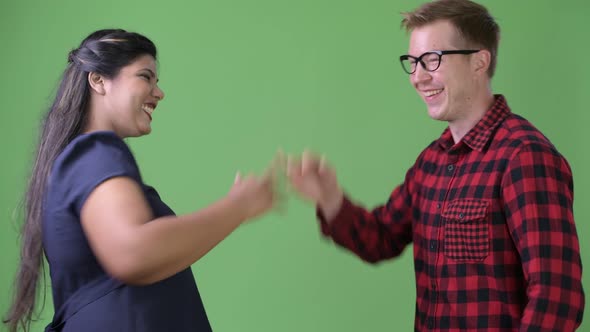 Young Multi-ethnic Business Couple Together Against Green Background