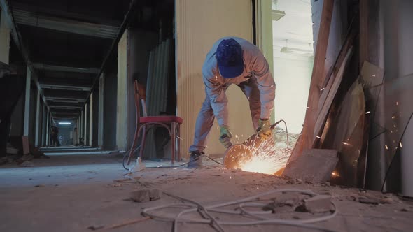 A Construction Worker Cuts Concrete Using a Grinder