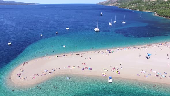 Aerial view of people sunbathing on a sandy beach on the island of Brac, Croatia