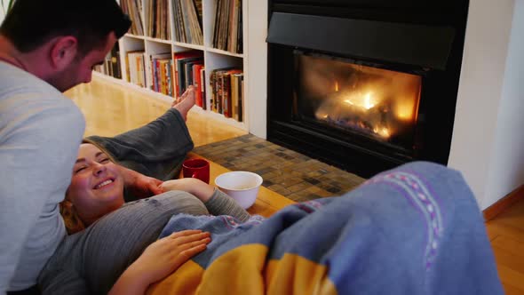 Couple relaxing near fireplace in living room