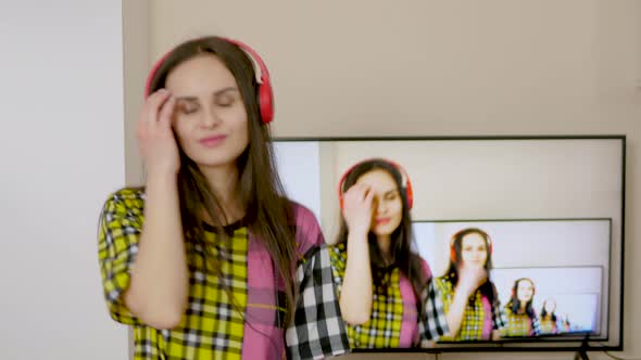 Young attractive woman with red headphones listens to music