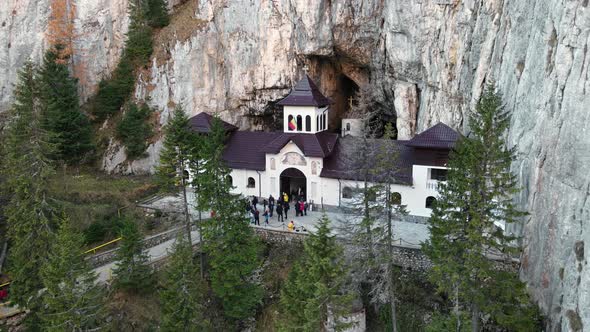 Aerial drone view of The Ialomitei Cave in Romania. Entrance into the cave with tourists in Bucegi M