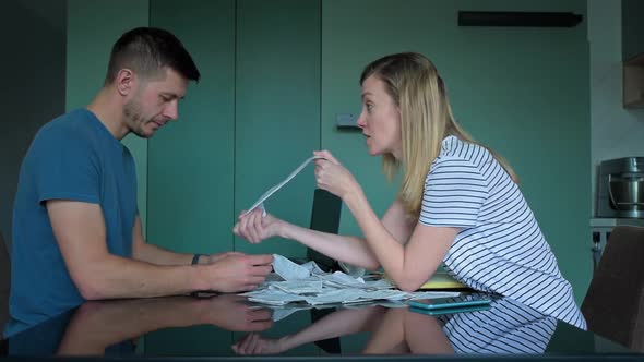 Man and Woman Looking at Payment Bills in the Kitchen