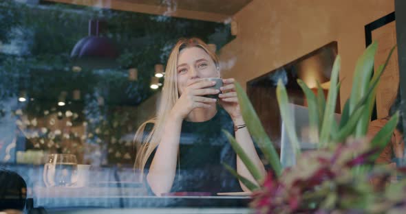 Beautiful Happy Girl Smiling Sitting and Drinking Enjoy a Cup of Coffee in Cafe