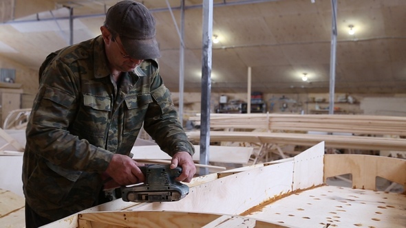 A Carpenter Polishes Details Wooden Boat at the Shipyard