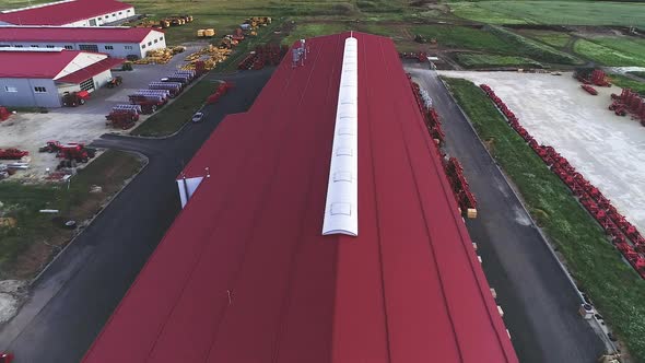 The Territory of an Industrial Plant. Large Hangars with a Red Roof. Aerial View, Evening Shooting