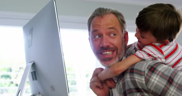 Father and son using desktop pc