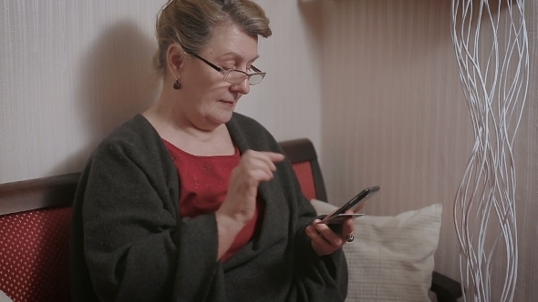 Elderly Lady Makes a Purchase Through The Internet With a Credit Card