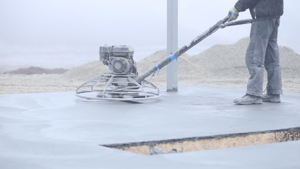 Worker Smoothes Concrete Surface