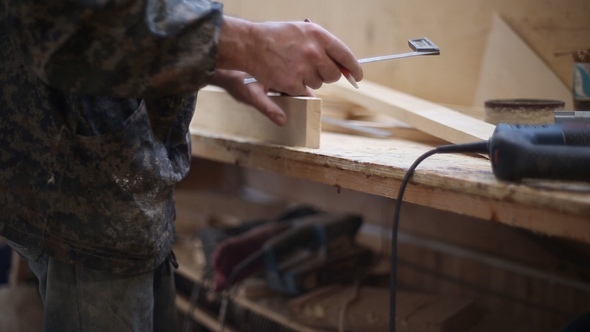 The Carpenter Measures with a Ruler and Pencil Making Marks