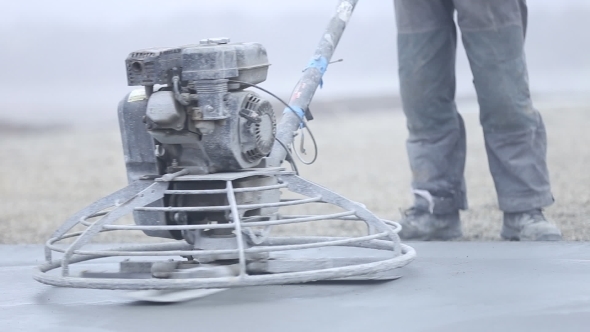 Worker Smoothes Concrete Surface