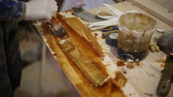 Carpenter Smears the Resin on a Fabric Tape at the Shipyard