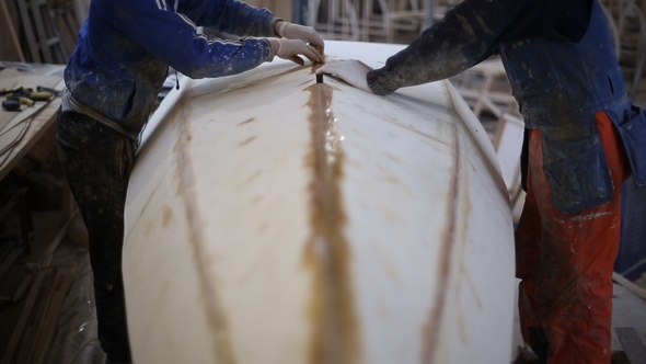 The carpenter Seals the Joints of the Boat at the Shipyard