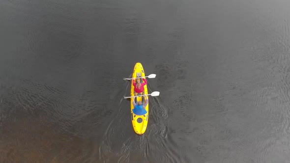 Animation of Caucasian people grumbling in a yellow canoe from a high view angle