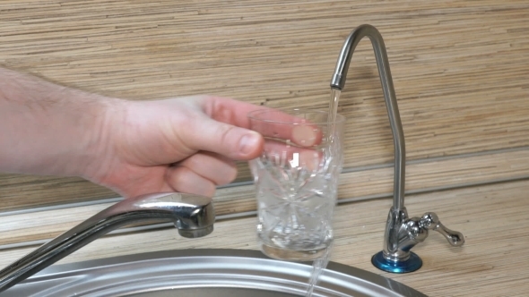 Hand Is Pouring a Glass Of Drinking Water From The Filter