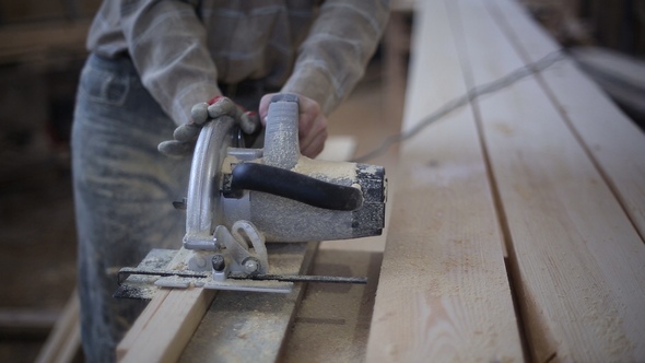 A Carpenter Saws Off a Board with a Disk Saw