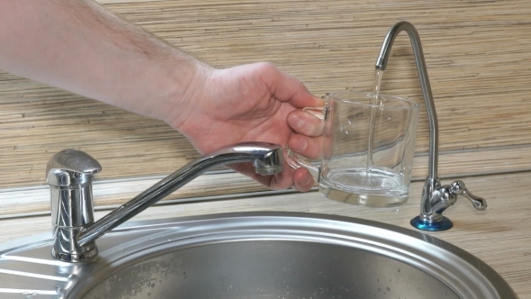 Hand Is Pouring a Glass Of Drinking Water From The Filter