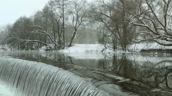 Ducks nearby Waterfall in the Winter River