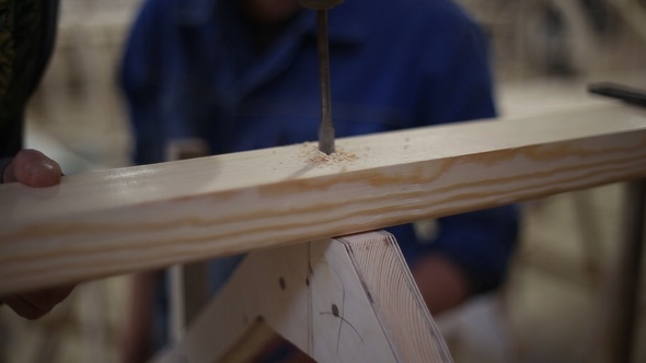 Carpenters Drill a Hole and Fasten a Screw with a Screwdriver